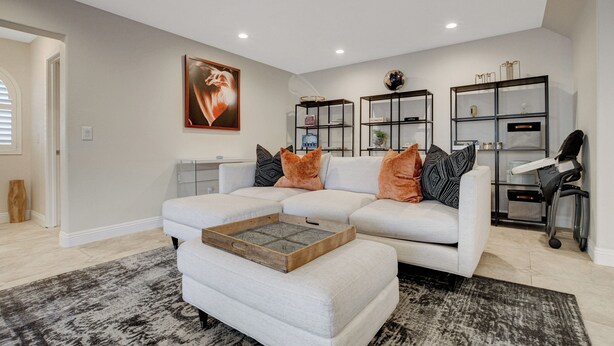 A modern living room with a sectional sofa, a coffee table, and built-in shelving. - Family Retreat: Pool & Fun Casita with Games (Las Vegas)