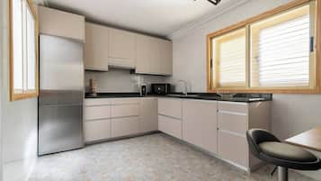 Een koelkast, een magnetron, een kookplaat, een vaatwasser