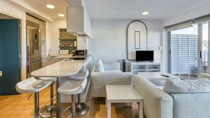 Una cocina moderna con comedor, televisor de pantalla plana y sofá.