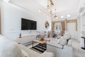 A modern living room with a large flat-screen TV, a sofa, a coffee table, and pendant lighting. - Villa 'Luxury Frontline Golf' with Private Pool, Wi-Fi and Air Conditioning (Torre Pacheco)