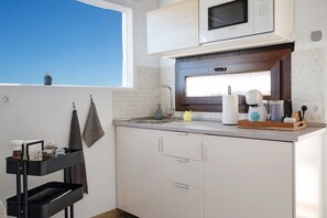 A modern kitchen with a built-in microwave, a sink, and a window above the counter.