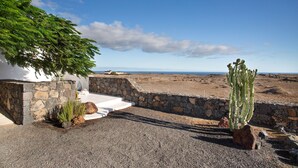 A stone wall, a cactus, and a view of the landscape. - Studio 'Apartment La Higuera' with Sea View, Wi-Fi, and Air Conditioning (Arrecife)