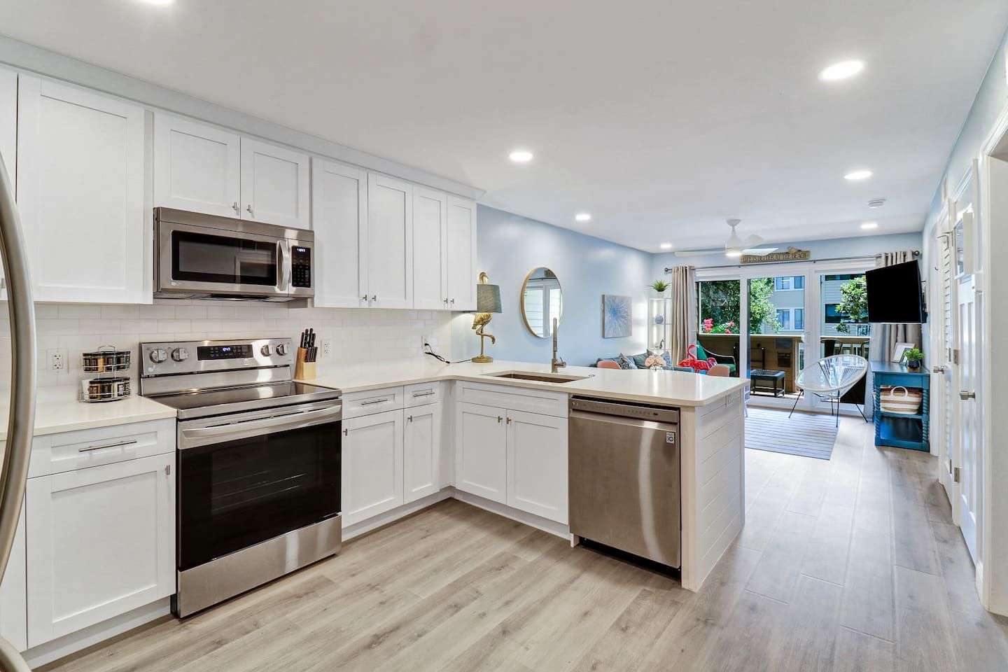 A modern kitchen with white cabinetry, stainless steel appliances, and a central island.