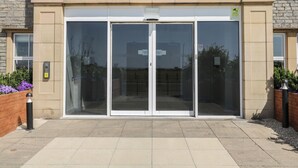 The entrance to Promenade House with a glass door and a sign above it. - The Studio (Weston-super-Mare)