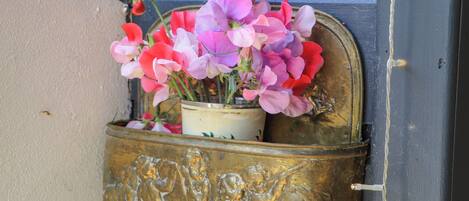 A brass mailbox with a floral arrangement.