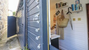 Een blauwe buitenmuur met een 'Crown Cabin' bord, een deur en een klein raam.
