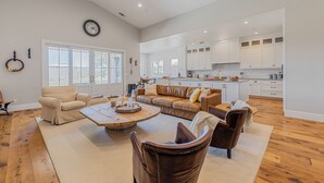A spacious living room with a large sofa, a coffee table, and a fireplace.