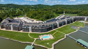 A large resort with multiple buildings, a swimming pool, and a lake.