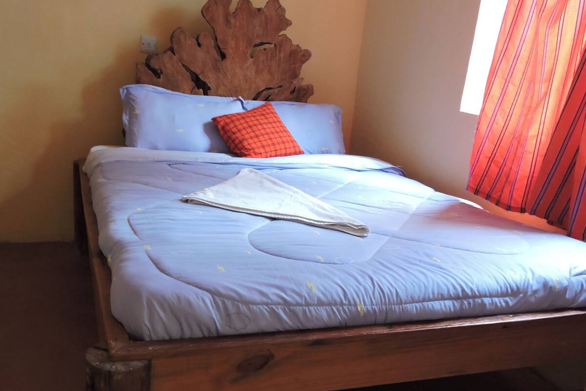 A bed with a wooden frame, a blue mattress, and a white blanket.