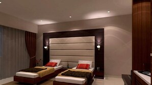 Un dormitorio moderno con dos camas, un cabecero grande y un aparador de madera.