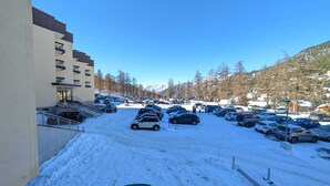 A snow-covered parking lot with cars and a building labeled "CHALMETTES" on the left.