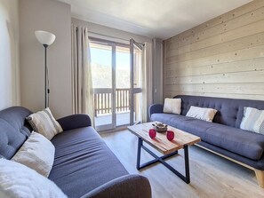 A modern living room with two grey sofas, a wooden coffee table, and a floor lamp.