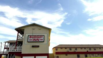 Un edificio con un letrero que dice "Budget Inn" y un cartel de "No hay habitaciones disponibles".