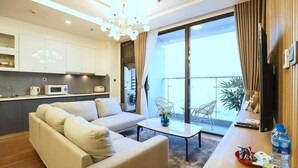 Ein modernes Wohnzimmer mit einer Couch, einem Couchtisch und Blick auf einen Balkon mit Gartenmöbeln.