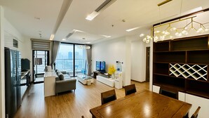Ein modernes Wohnzimmer mit Essbereich, großen Fenstern und Blick auf die Stadt.