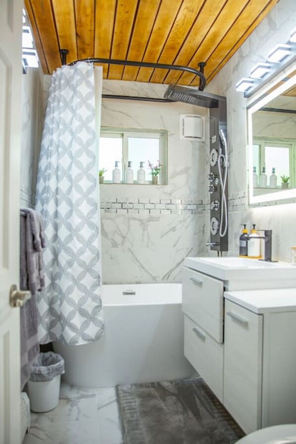 Un baño moderno con ducha, bañera y tocador.