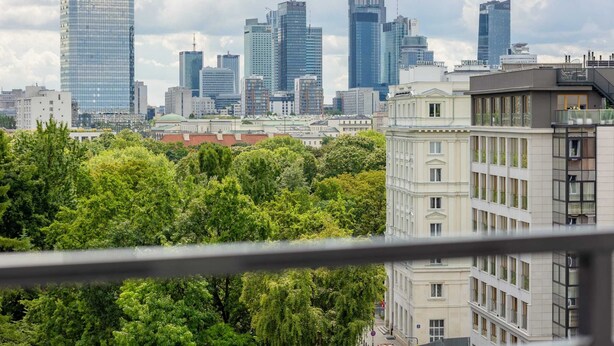 Eine Skyline mit modernen Wolkenkratzern und üppigen Grünflächen.