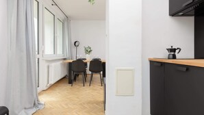Eine moderne Küche mit einem schwarzen Schrank, einer Holz Arbeitsplatte und einer Kaffeemaschine.