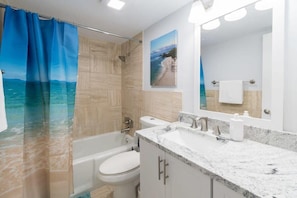 Bathtub, hair dryer, towels, shampoo