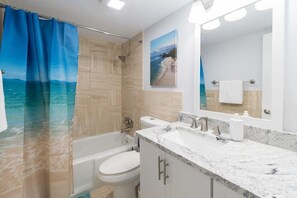 Bathtub, hair dryer, towels, shampoo