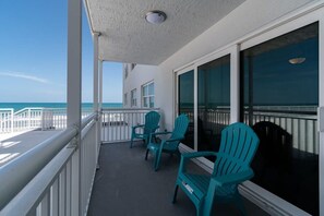 Ein Balkon mit Stühlen und Blick auf den Ozean.