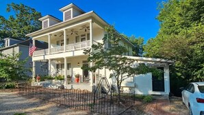 A two-story house with a porch, a flag, and a car parked in front. - Spa Tub, Historic B & B, Get Spoiled! (Eureka Springs)