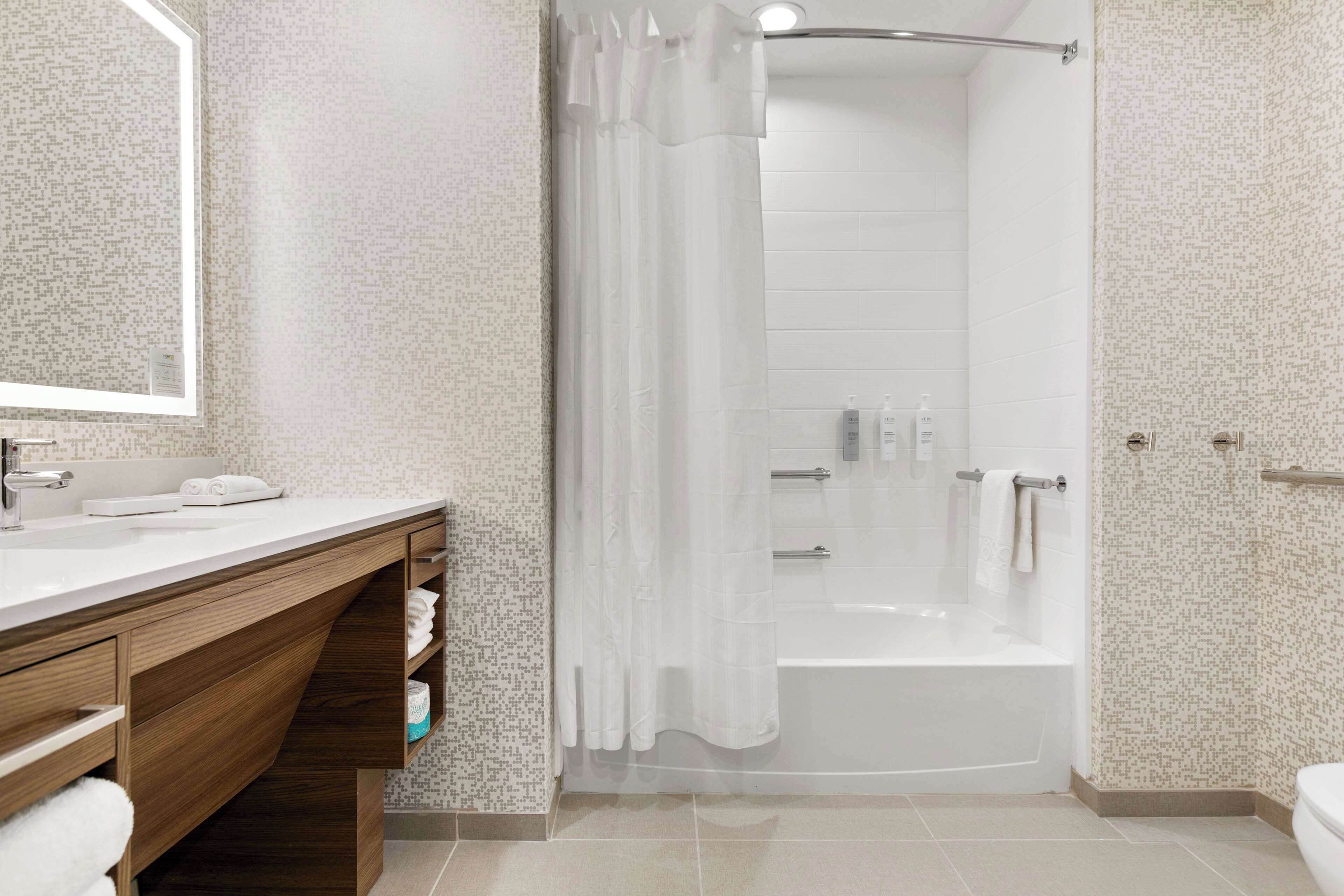 A modern bathroom with a shower, toilet, and vanity.