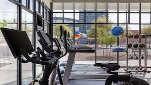 A gym with stationary bikes, treadmills, and a weight rack.