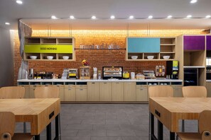 A modern cafe with a brick wall, wooden furniture, and a 'Good Morning' sign. - Home2 Suites by Hilton Phoenix Downtown (Phoenix)