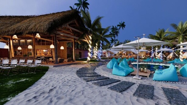 A beachside resort with a thatched-roof bar, lounge chairs, and tiki-style umbrellas. - TENT GLAMPING -MUINE SUN & SEA  (Mui Ne)