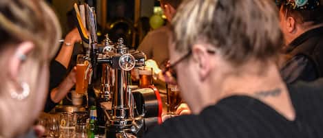 Un espace bar avec un robinet, des verres et des bouteilles.