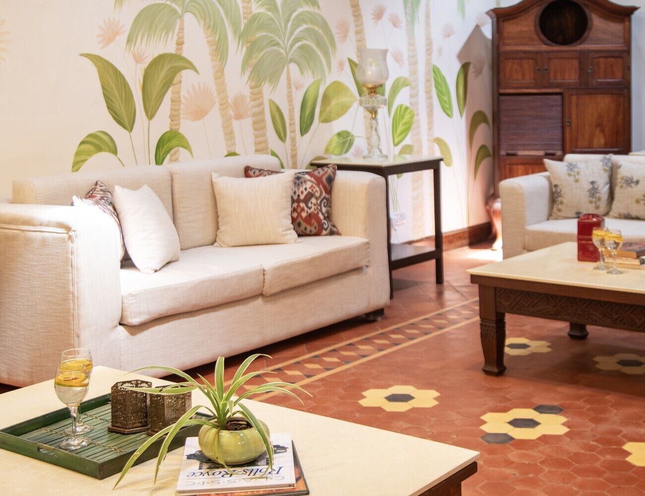 A living room with a sofa, a coffee table, and a patterned floor.