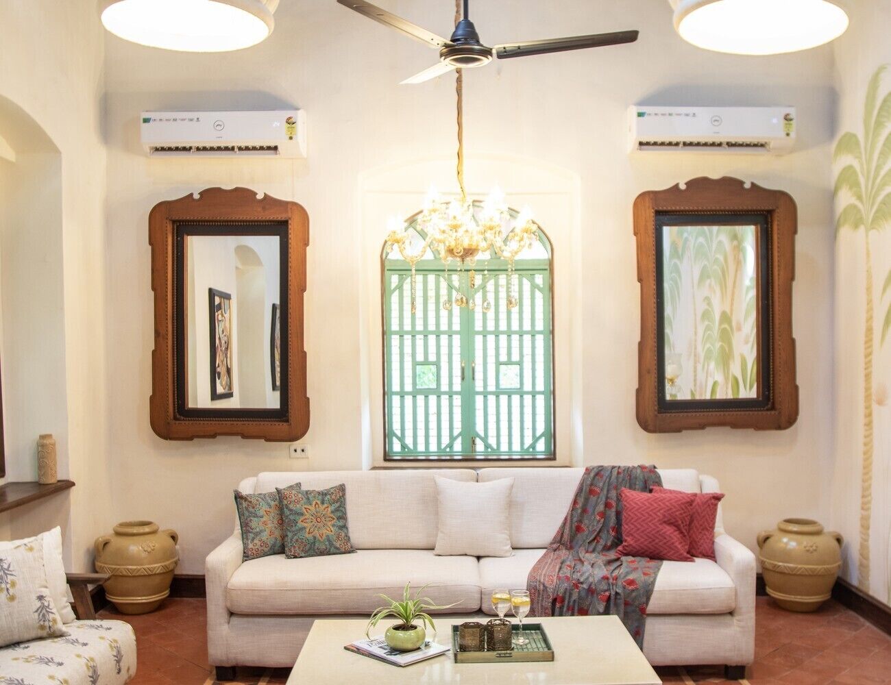 A living room with a sofa, a coffee table, and a decorative mirror.