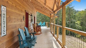 A wooden deck with Adirondack chairs and a sign reading "Relax you're in the MOUNTAINS". - Brand New 5 Bedroom with Arcade, WiFi, Hot Tub!  Located in Thunder Mtn Resort! (Sevierville)