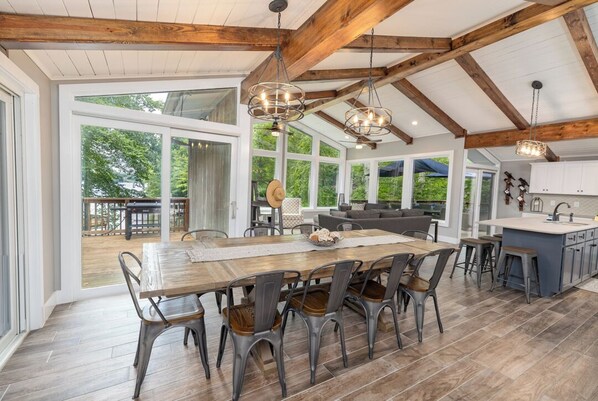 A spacious kitchen with a large island, wooden beams, and pendant lighting.