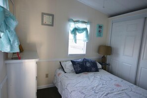 A bedroom with a bed, a window with curtains, a bedside lamp, and a door. - Home in private gated community - Assateague Pointe/tons of fun amenities (Berlin)