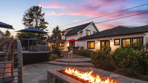A patio area with a fire feature, outdoor seating, and a staircase leading to a covered deck. - Spectacular Healdsburg Manor-4BR/4.5BA, POOL+2 SPA! (Healdsburg)