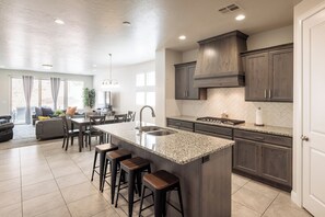 Enjoy cooking in this well-equipped kitchen with a large island, sink, and ample counter space.