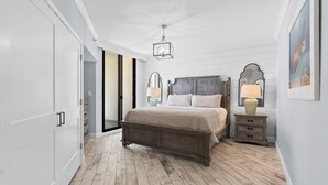 Un dormitorio con cama de madera, paredes blancas y suelo de madera.