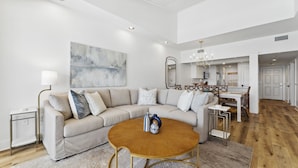 A modern living room with a sectional sofa, a round coffee table, and a minimalist decor style.