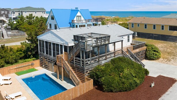 A beachfront property with a swimming pool, wooden deck, and a view of the ocean. - Pleasant Seaprise: Private Pool, 200ft. to Beach (Nags Head)