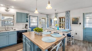 A modern kitchen with blue cabinets, a wooden island, and pendant lighting. - Pleasant Seaprise: Private Pool, 200ft. to Beach (Nags Head)
