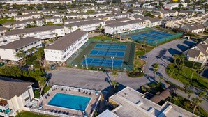 A residential area with multiple apartment buildings, a large swimming pool, and tennis courts. - Sandpiper Cove #9224 | Across from the Beach | Snowbird Friendly (Destin)