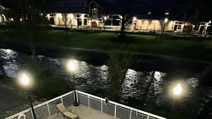 Une piscine à bord incurvé, entourée d’une clôture blanche et dotée d’une terrasse dallée.