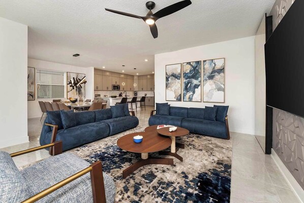 A modern living room with a sectional sofa, a coffee table, and a TV.