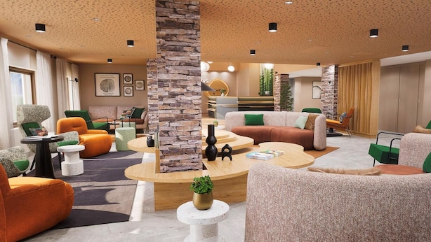 A modern hotel lobby with a stone accent wall, multiple seating areas, and a reception desk.
