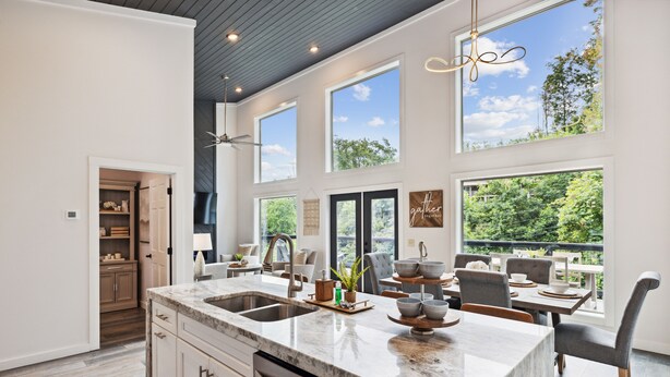 A spacious kitchen with a large island, built-in appliances, and a dining area with a view of the outdoors. - Sunset Chalet 2 Bedroom Cabin by RedAwning (Gatlinburg)