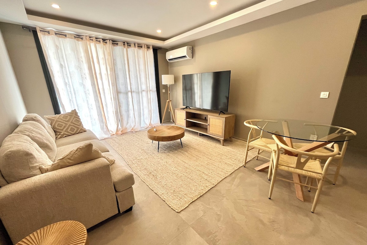 Una sala moderna con un sofá, una mesa de vidrio y un televisor.