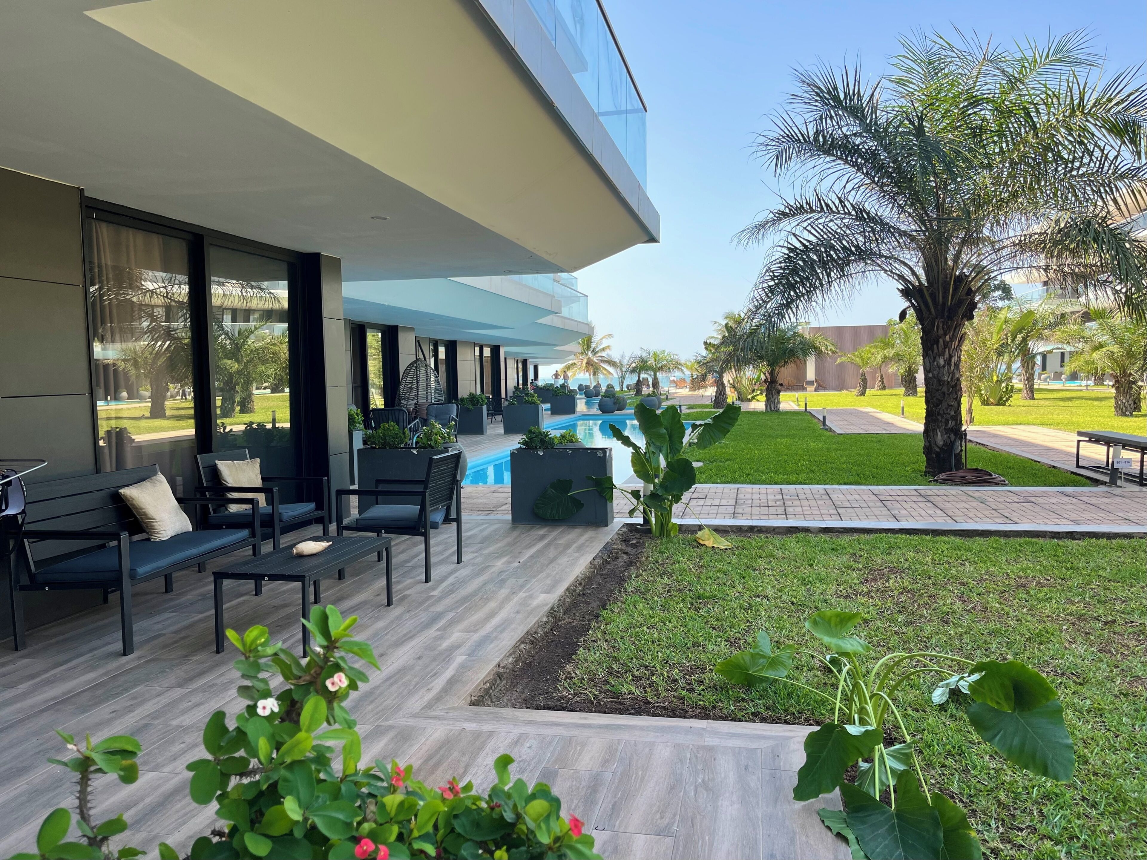 A modern outdoor area with a pool, seating, and greenery.