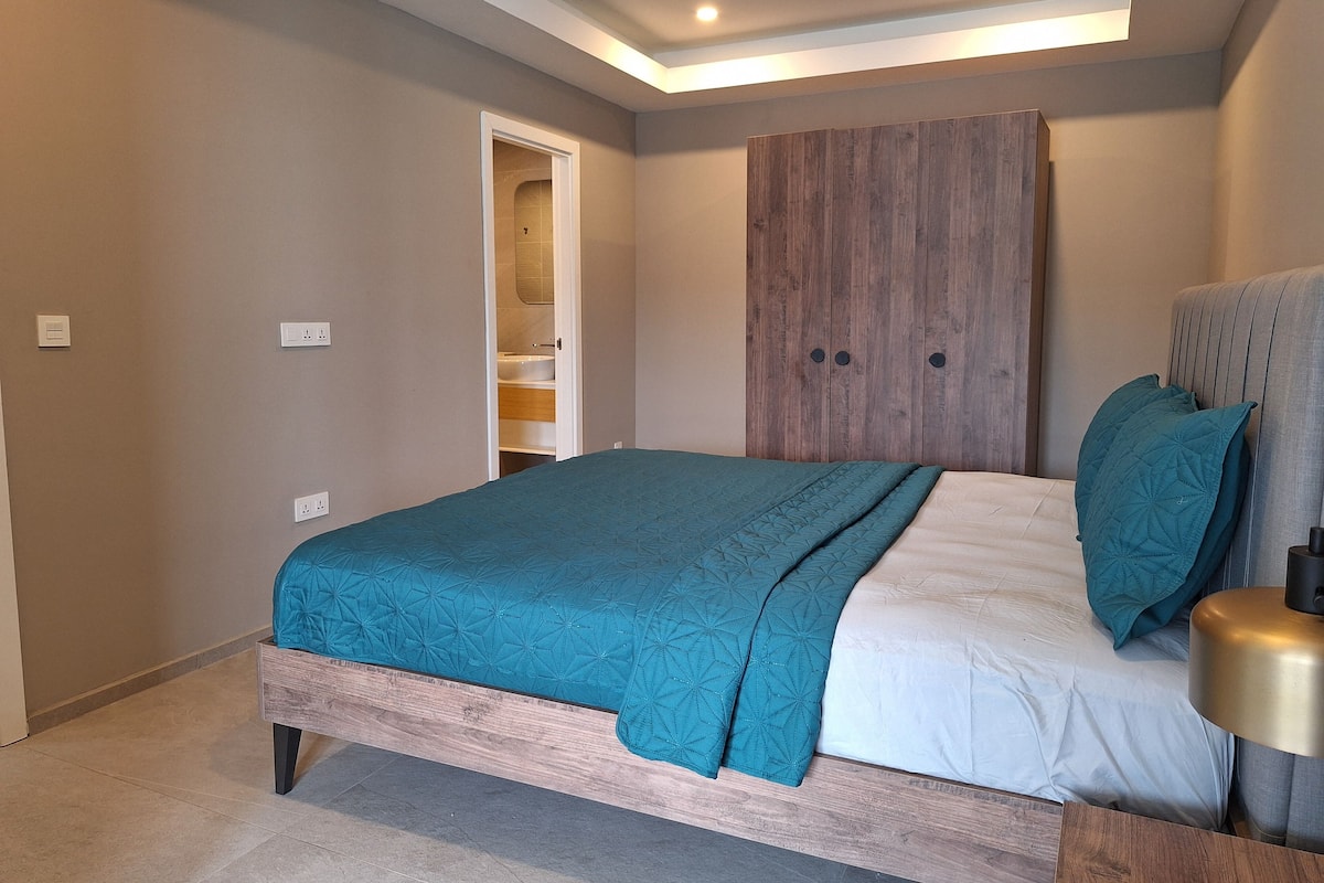 Un dormitorio con cama, armario y mesita de noche.